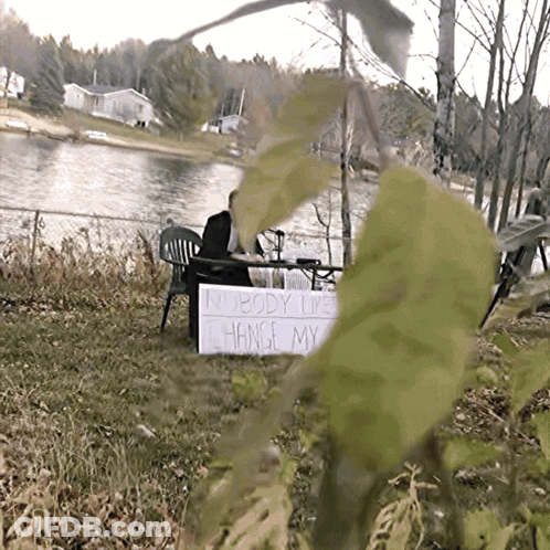 Nobody Likes Change Sign In Front Of Lake GIF