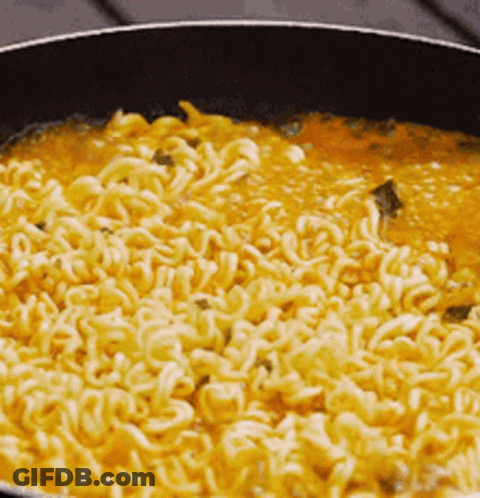 Noodles Are Being Cooked In A Pan With Sauce . GIF
