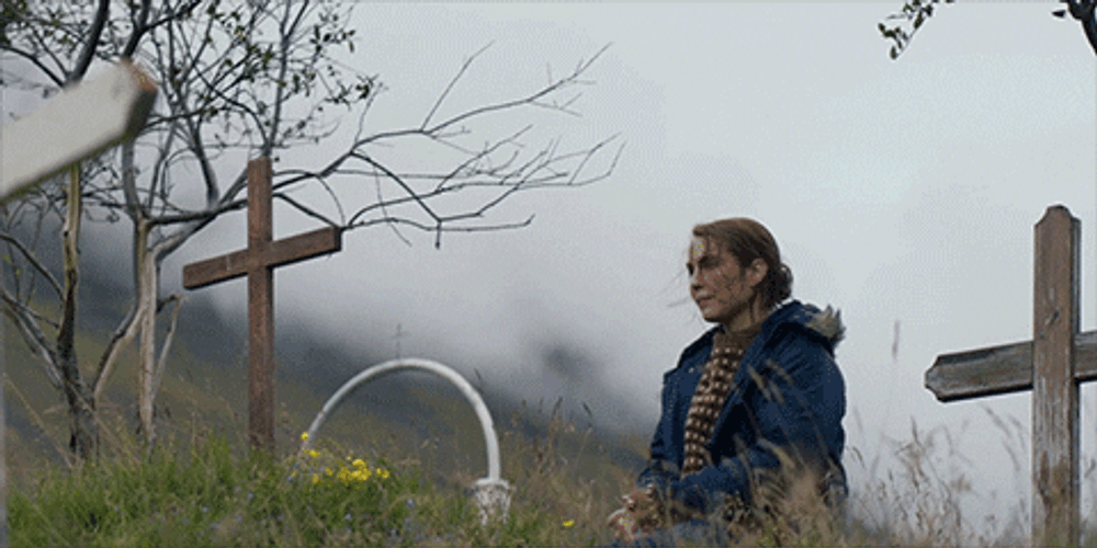 Noomi Rapace Praying To Graveyard Cross GIF