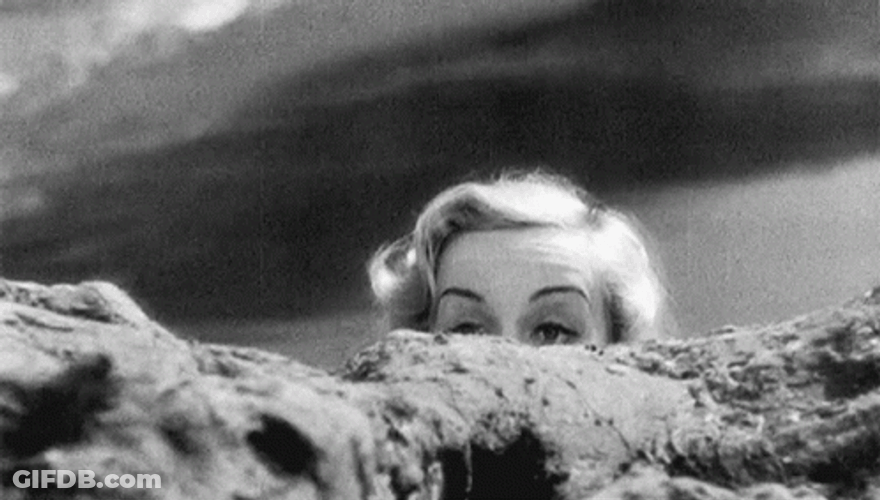 Nosy Carole Lombard Peeking From A Boulder GIF