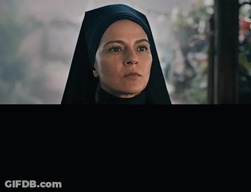 Nun In Black Veil And Necklace Looking GIF