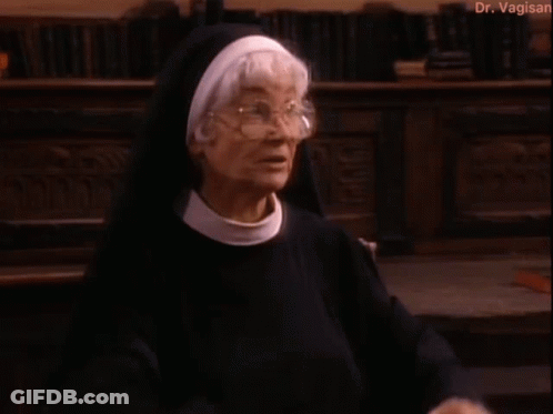 Nun Standing In Front Of Bookshelf GIF