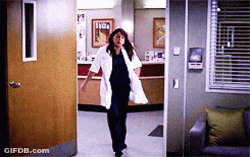 Nurse In Lab Coat Walking Through Doorway GIF