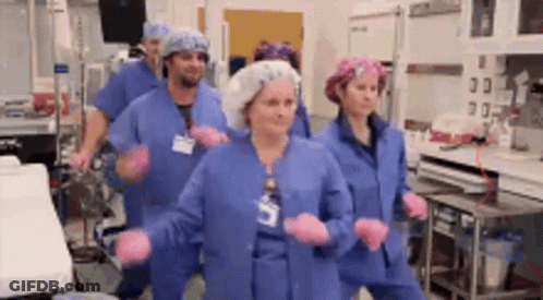 Nurses Dancing In Blue Scrubs And Pink Gloves GIF