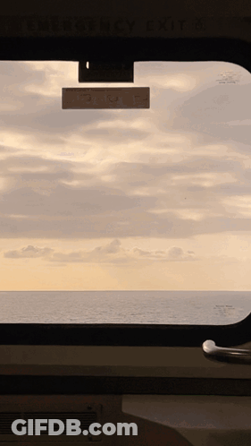 Ocean View Through Window With Emergency Exit Sign GIF