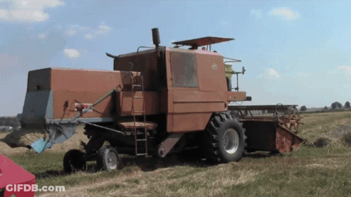 Old Rusty Combine Harvester Parked In Grass GIF
