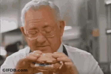 Older Man Eating Hamburger With Eyes Closed GIF