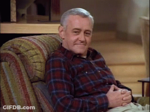 Older Man In Plaid Shirt Sitting In Chair GIF