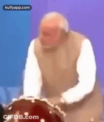 Older Man Playing Drum In Blurry Photo GIF
