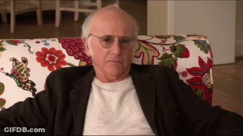 Older Man With Glasses In Floral Chair GIF