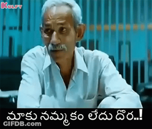 Older Man With Mustache Sitting At Table Telugu Caption GIF
