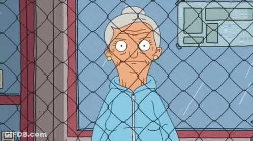 Older Woman Behind Chain Link Fence GIF