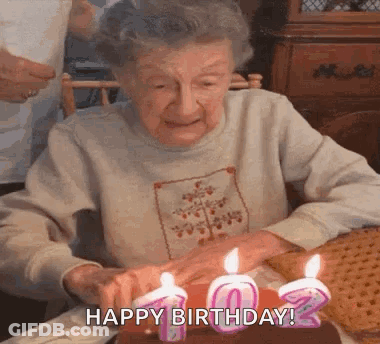Older Woman Blowing Out Birthday Candles GIF