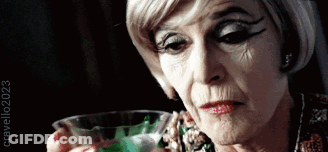 Older Woman Holding Glass Of Green Liquid 2023 GIF