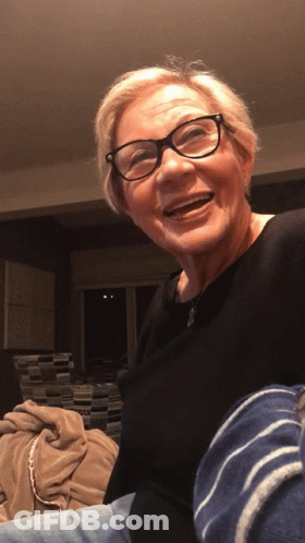 Older Woman In Glasses And Black Shirt Smiling GIF