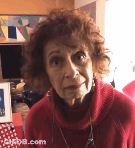 Older Woman In Red Sweater And Earrings Looking GIF