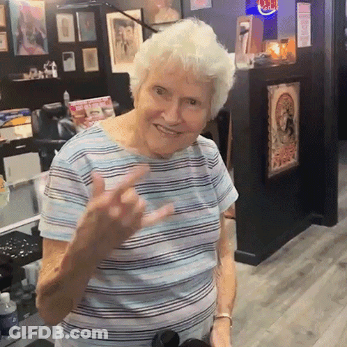 Older Woman In Striped Shirt Giving Middle Finger GIF