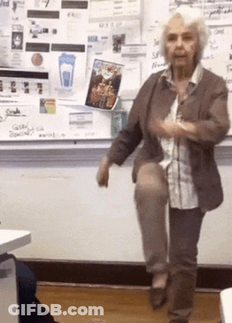 Older Woman On One Leg At Whiteboard With Blue Cup GIF