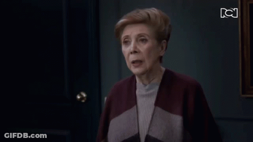 Older Woman Standing In Front Of Door With BC GIF