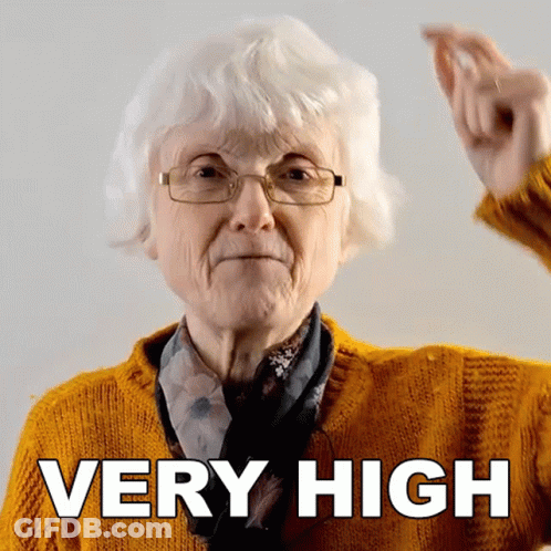 Older Woman Wearing Glasses And Yellow Sweater Says Very High GIF