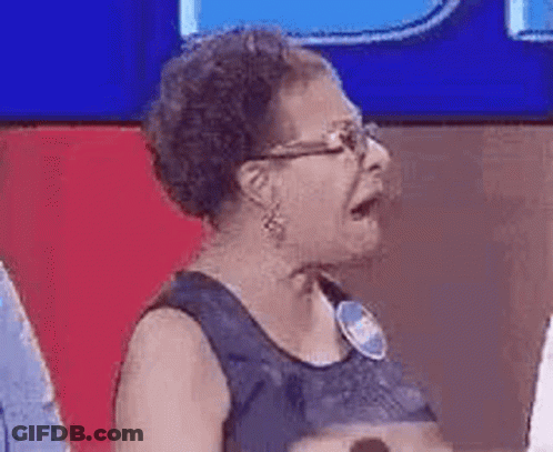 Older Woman Wearing Glasses Sitting At Microphone On TV Show GIF