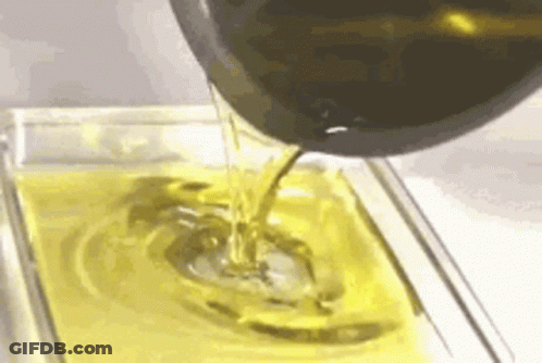 Olive Oil Is Being Poured Into A Glass Dish . GIF