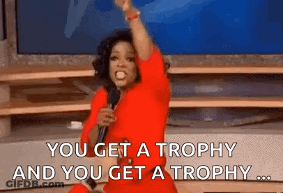 Oprah Winfrey Is Holding A Microphone And Saying `` You Get A Trophy And You Get A Trophy ... '' . GIF