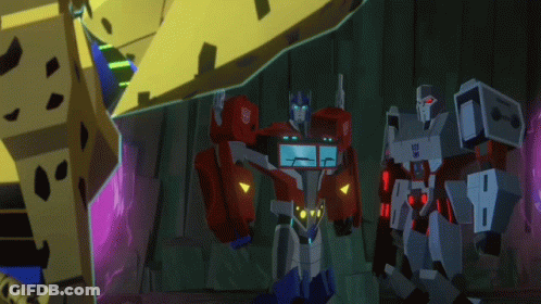 Optimus Prime And Megatron Standing In Dark Room GIF