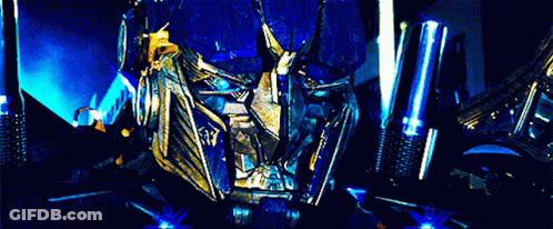 Optimus Prime And Megatron Standing Next To Each Other In Dark Room GIF