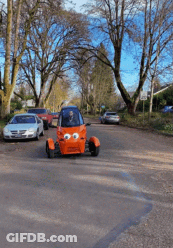Orange Car With Big Eyes Driving Down Street GIF