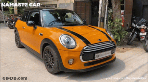 Orange Mini Cooper Parked In Front Of Building Namaste Car GIF