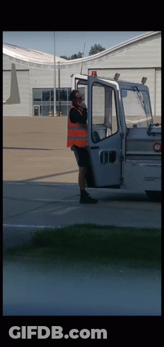 Orange Vest Man On Phone Near White Vehicle GIF