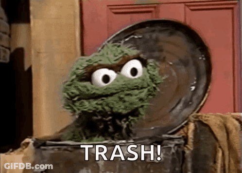 Oscar The Grouch From Sesame Street Is Sitting In A Trash Can With The Word Trash Written On It . GIF