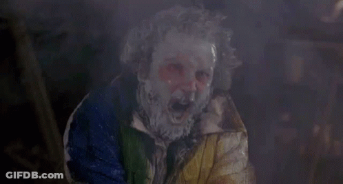 Paint-Covered Person In Clown Mask And Colorful Jacket GIF