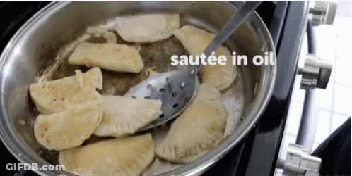 Pan Of Food Being Sauteed In Oil With Spatula GIF