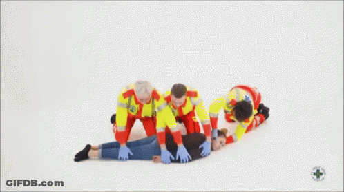 Paramedics Helping Woman Lying On Floor GIF