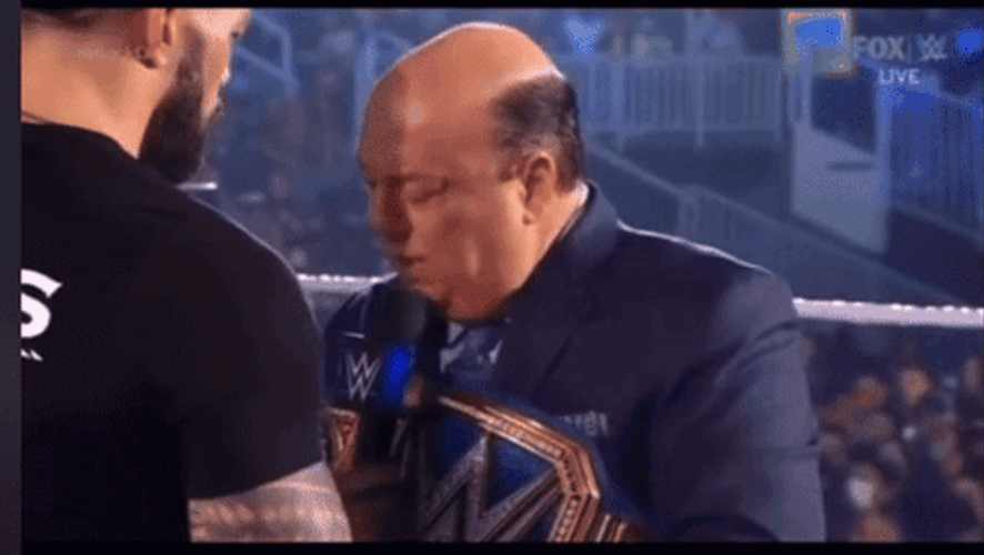 Paul Heyman Hold Face By Roman Reigns GIF