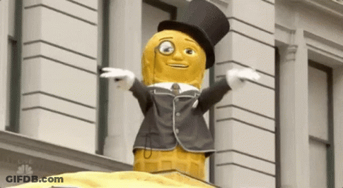 Peanut Mascot In Top Hat And Suit In Front Of Building GIF