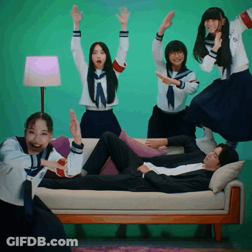 People Around Man On Couch With Arms Up GIF