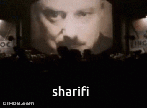 People Before Screen With Man's Face And Sharifi GIF