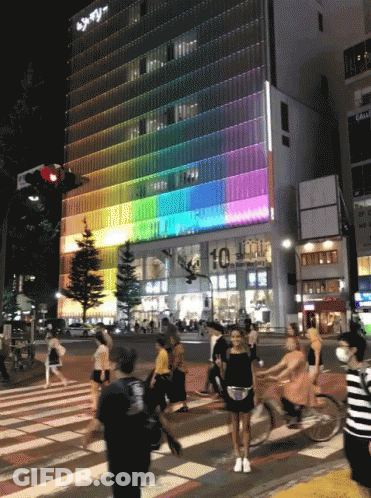 People Crossing Street Near Building 10 GIF