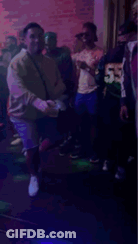 People Dancing In Club With Purple Lights GIF