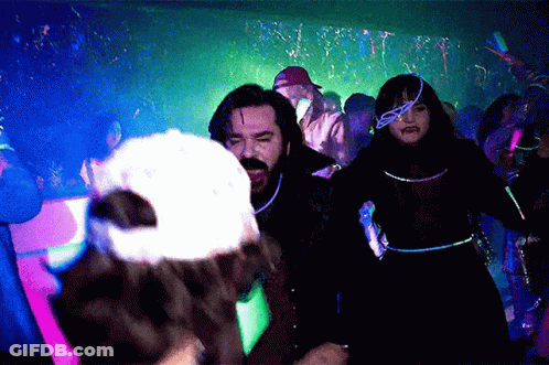 People Dancing In Dark Room With Glow Confetti GIF