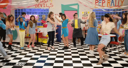 People Dancing In Diner With Pep Rally Sign GIF
