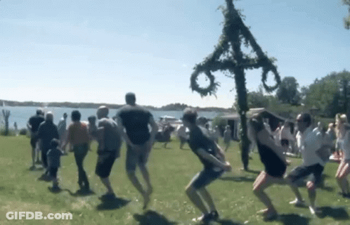 People Dancing In Field Front Of Cross GIF
