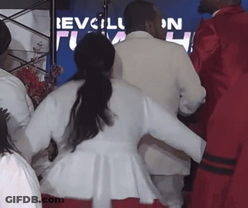 People Dancing In Front Of Revolution Sign GIF