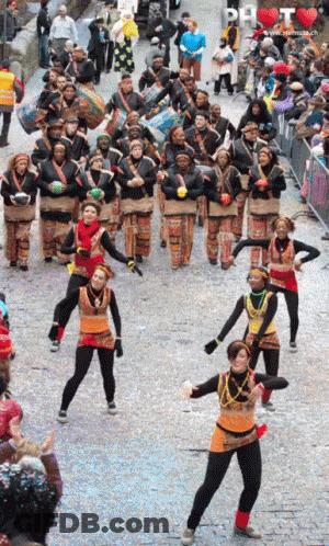 People Dancing In Parade With DH Sign GIF