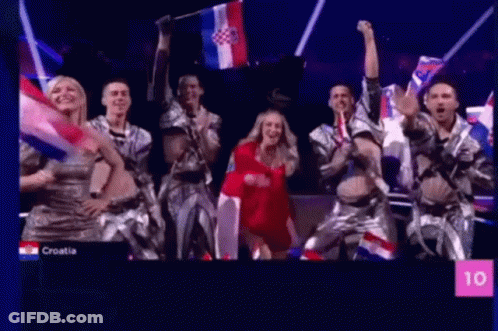People Dancing On Stage Holding Flags GIF