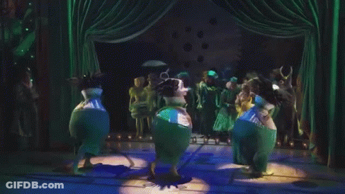 People Dancing On Stage With Green Curtains GIF