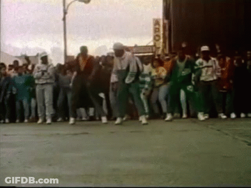 People Dancing On Street In Front Of Building GIF